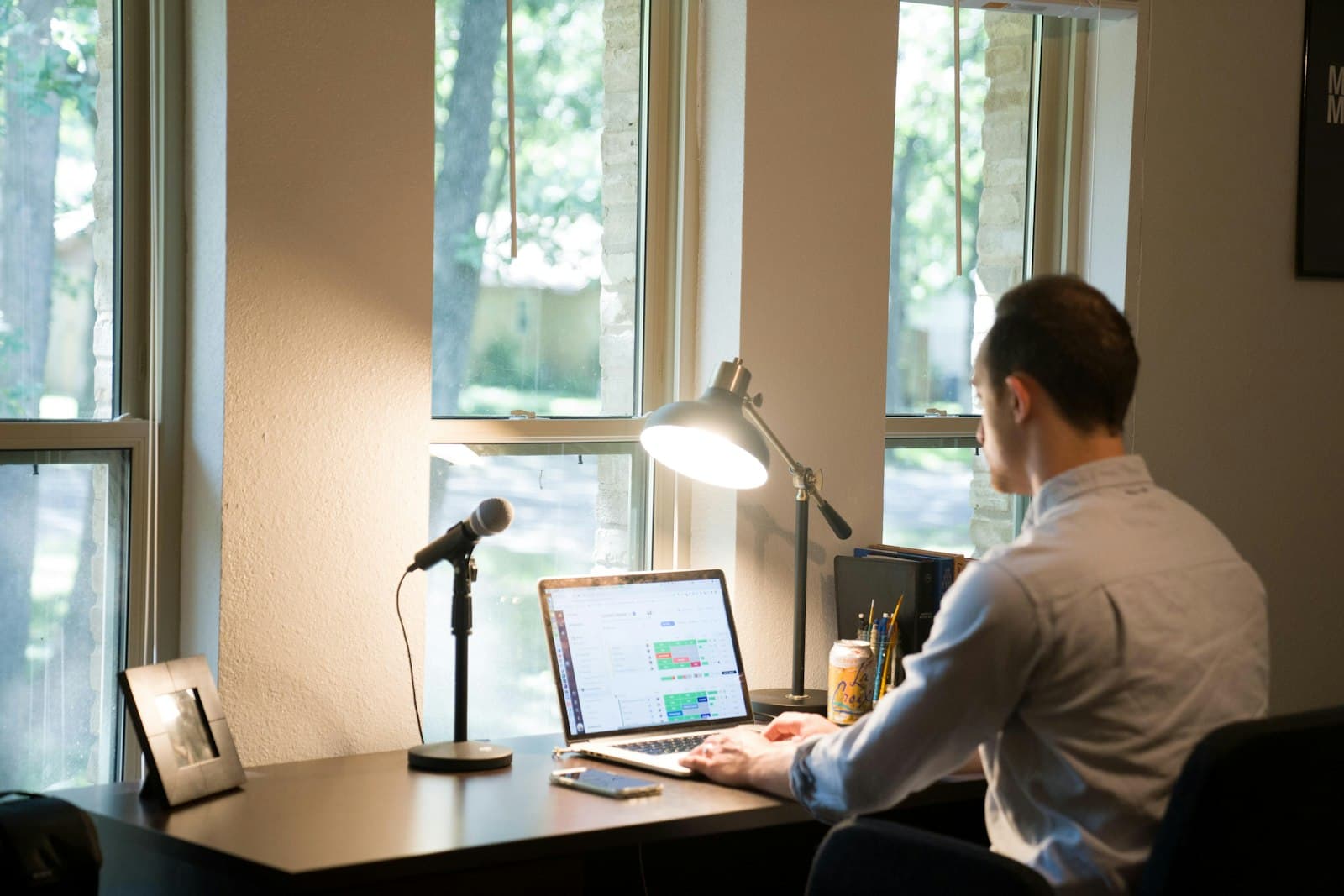 A person working on a laptop at a home desk.