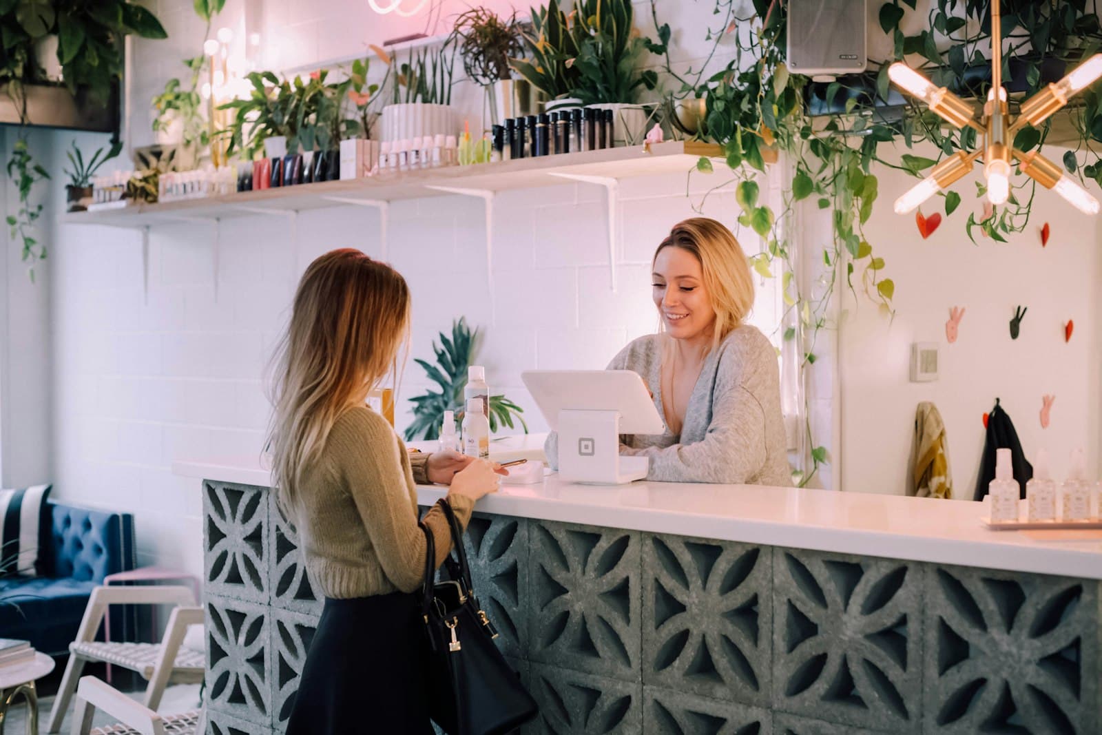 A customer paying at the counter of a small plant shop.